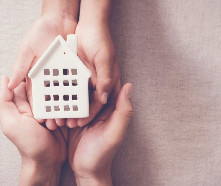 hands holding toy house